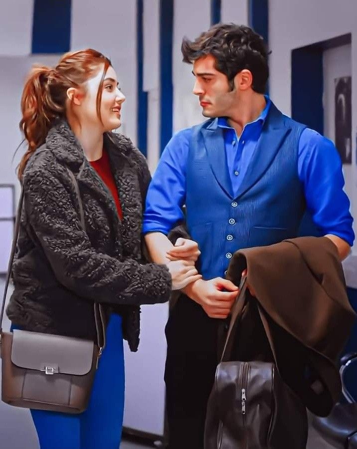 a man and woman standing next to each other in front of lockers holding hands