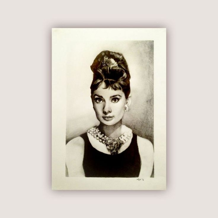 a black and white photo of a woman wearing a necklace with her hair in a bun