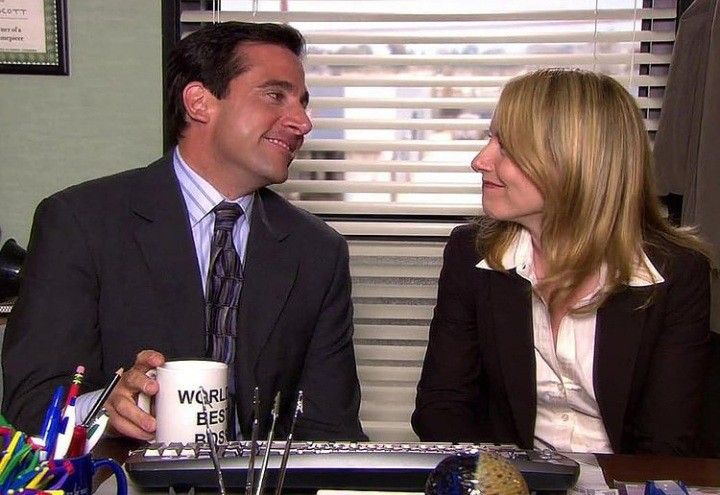 a man and woman sitting at a desk talking