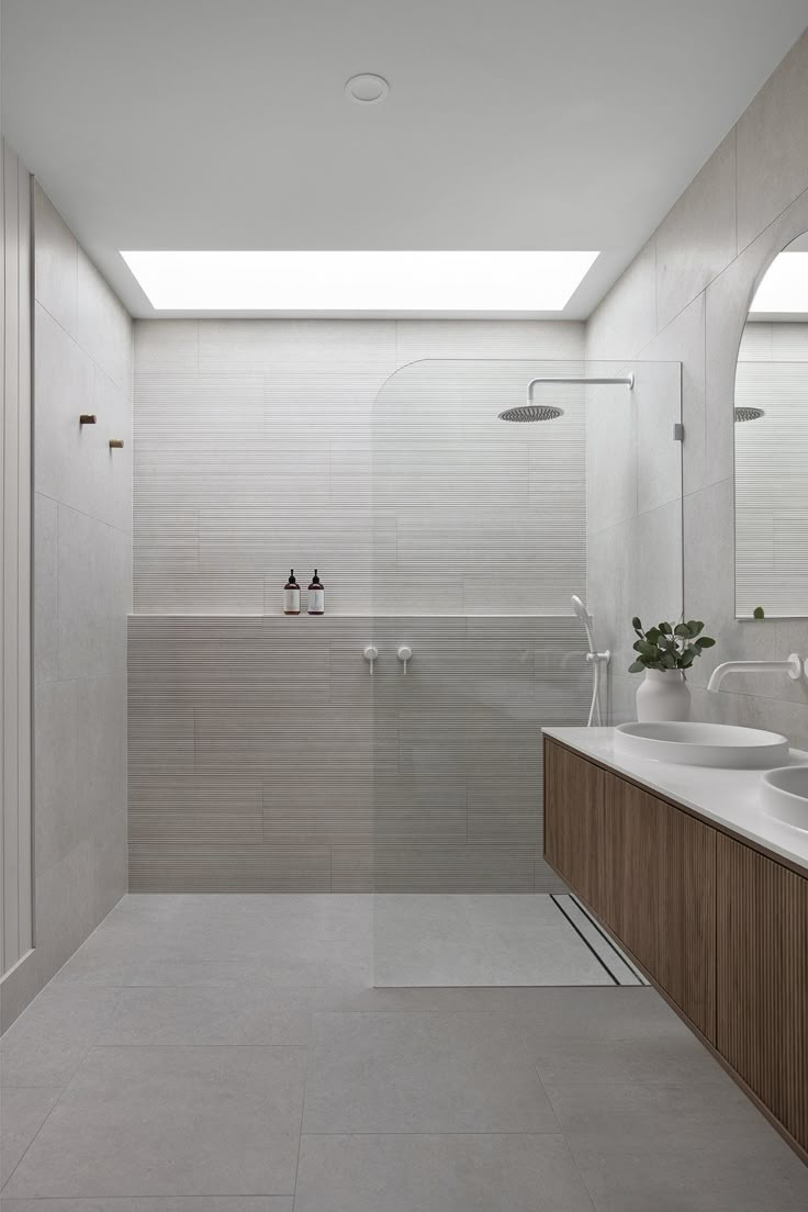 a large bathroom with two sinks and a shower stall in the middle of the room