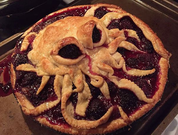 a pie with some toppings on it sitting on top of a pan in the oven