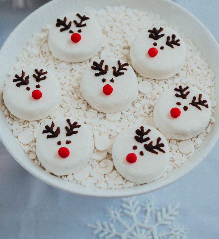 snowmen made out of marshmallows in a white bowl on a table