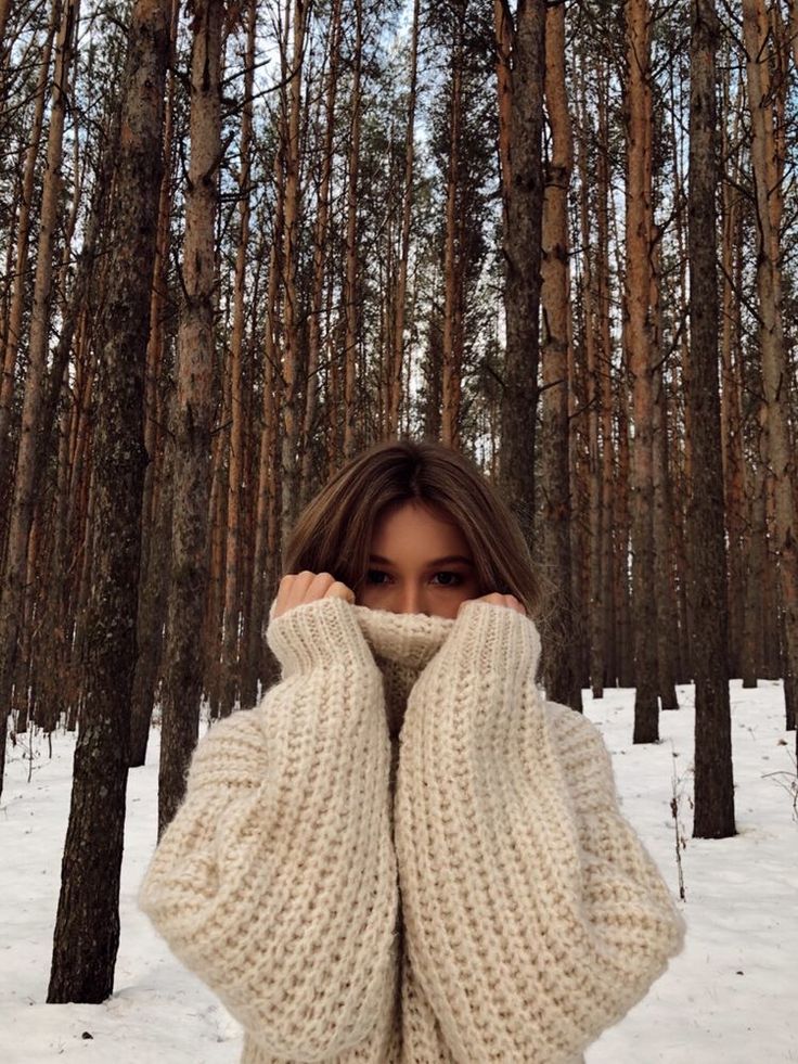 a woman is covering her face in the snow