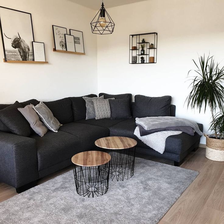 a living room with grey couches and pictures on the wall above it, along with a coffee table