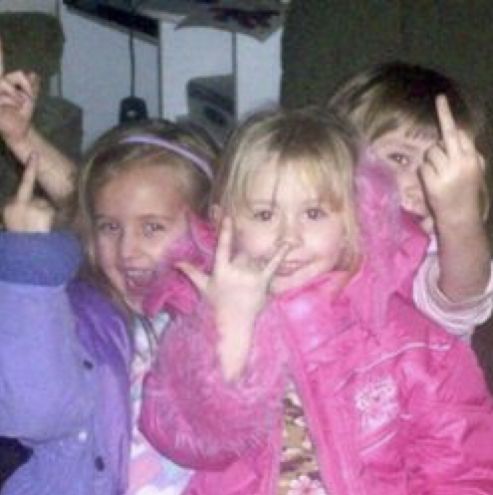 three children are posing for the camera with their hands up and fingers in the air