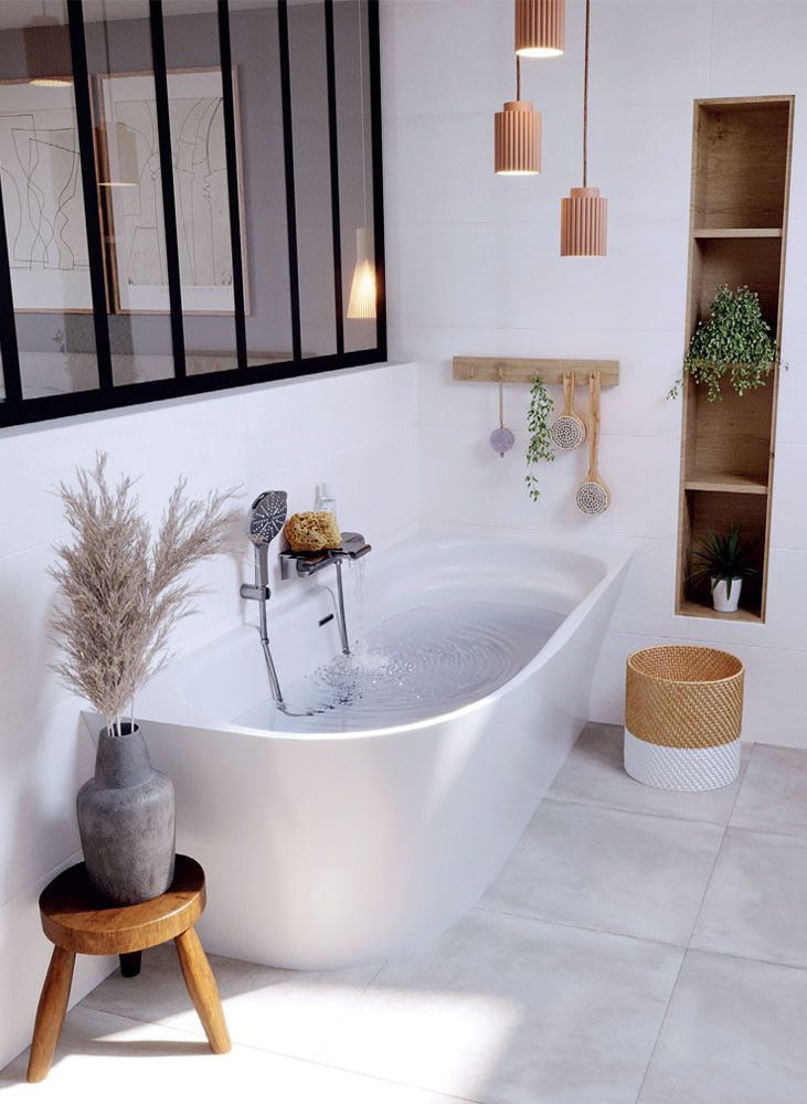 a white bath tub sitting in a bathroom next to a wooden stool and shelf filled with potted plants