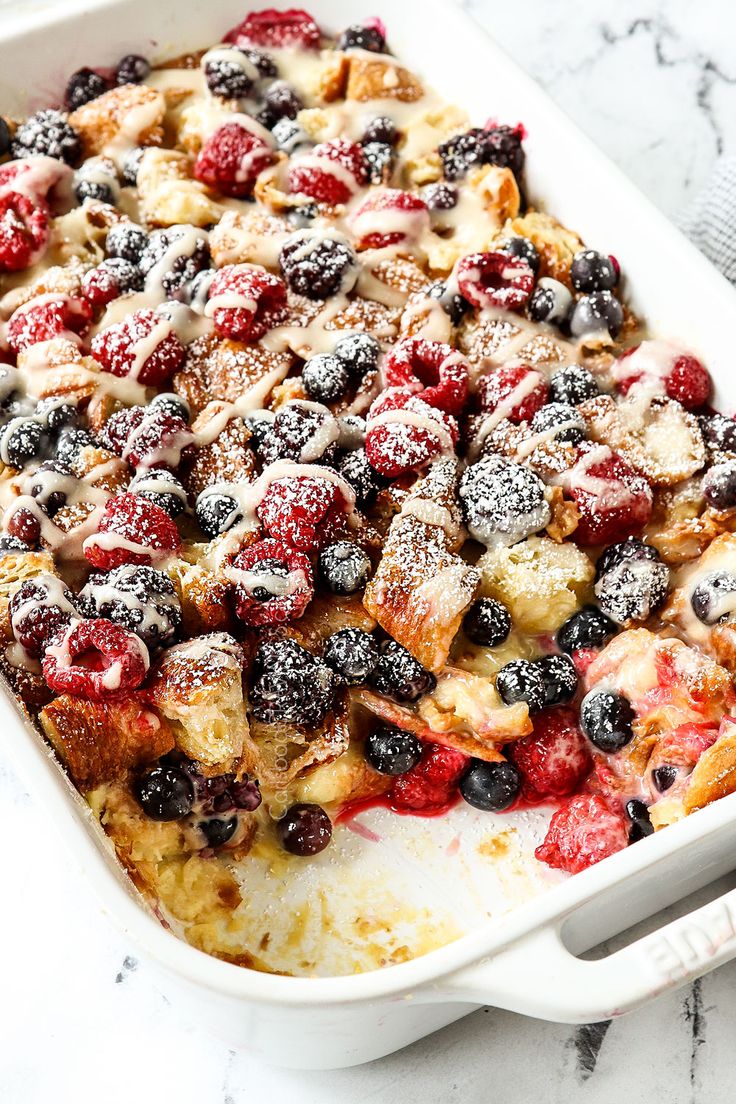 a casserole dish filled with berries and french toast