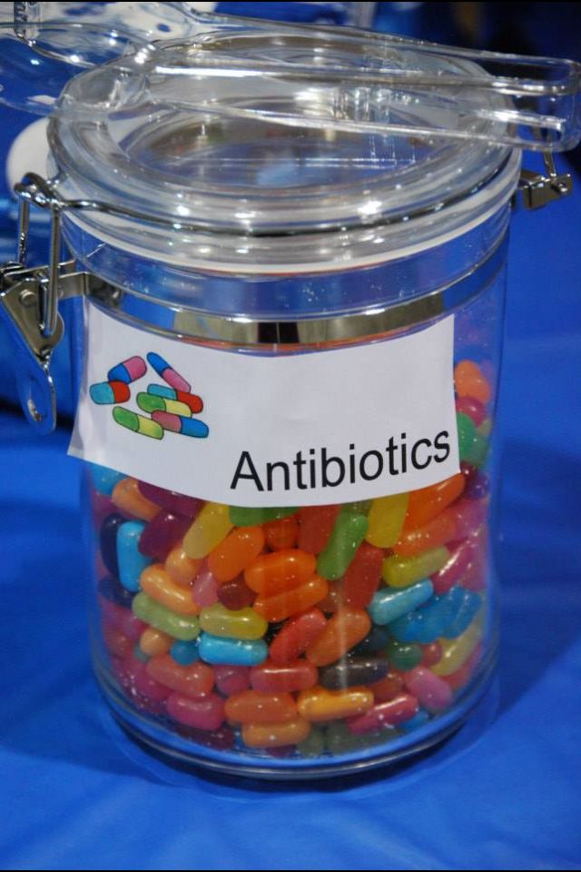 a glass jar filled with lots of colorful candies on top of a blue table