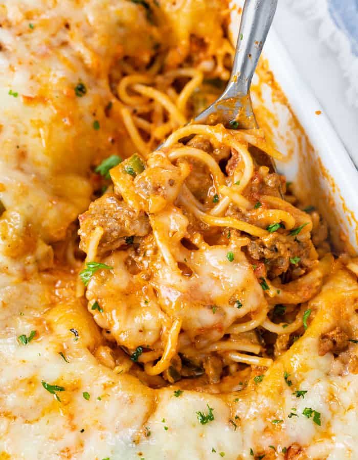 a casserole dish with meat, cheese and noodles in it is being eaten by a fork