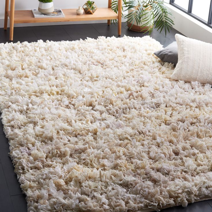 a large white rug on top of a hard wood floor