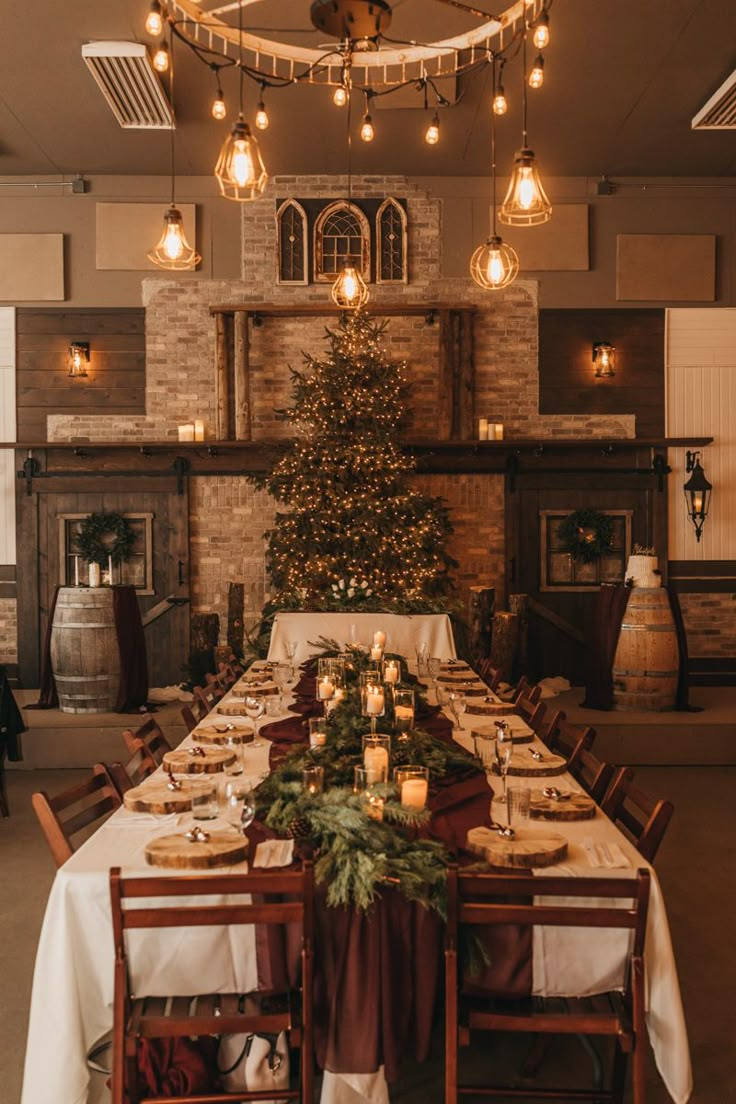 a dining room table set for christmas dinner with candles and greenery on the table