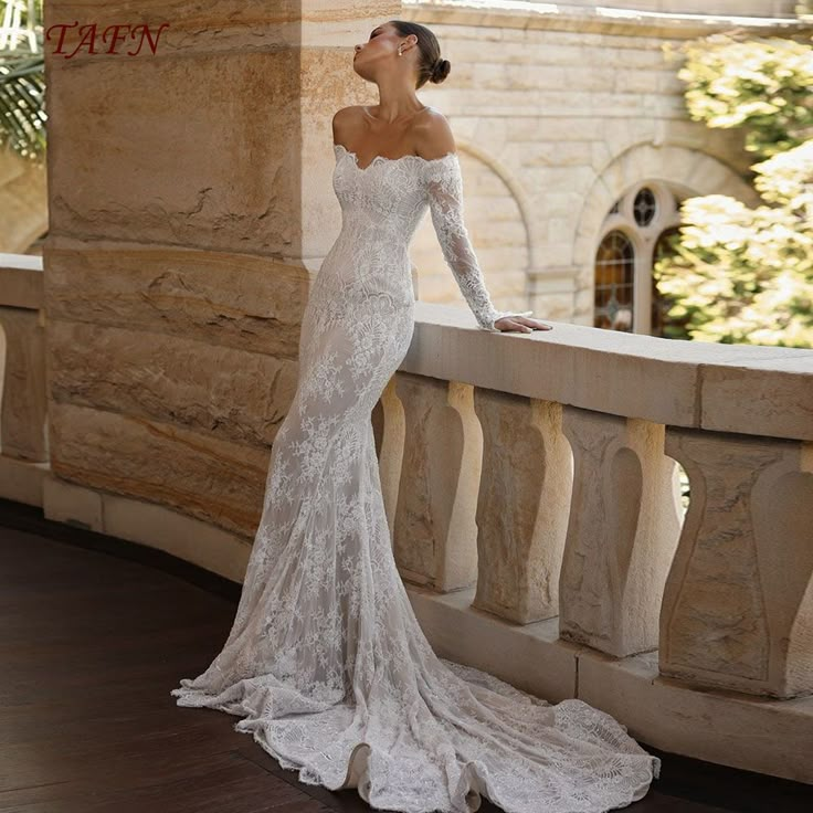 a woman in a wedding dress standing on a balcony