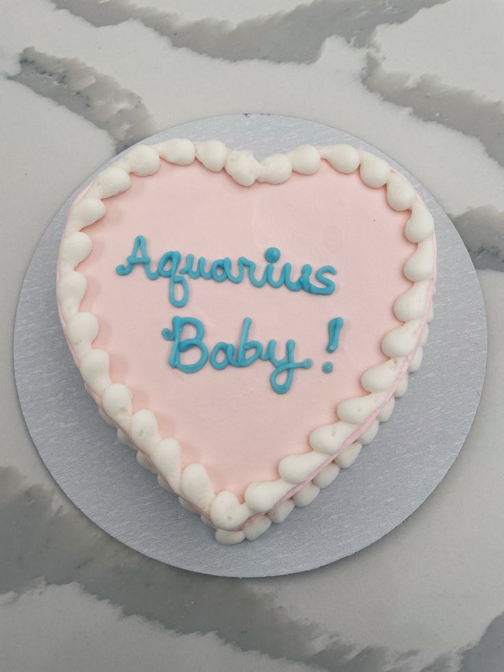 a heart shaped cake with the words aquarius's baby written on it