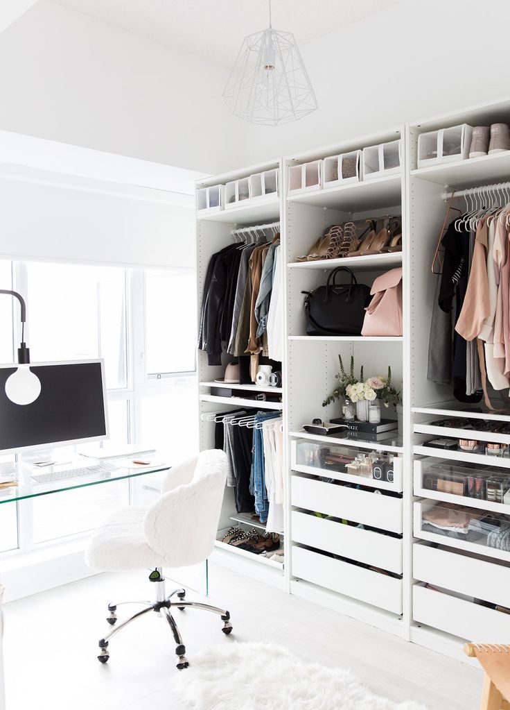 a white closet filled with lots of clothes and bags next to a computer monitor on top of a desk