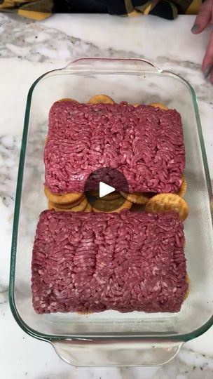 a square glass dish filled with meat and pretzels on top of a marble counter