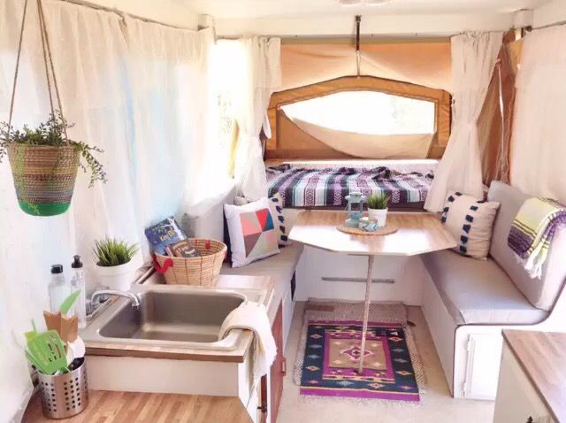 the inside of a small camper with lots of furniture and decor on it's walls