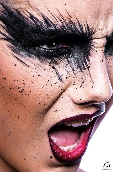 a close up of a woman's face with black makeup