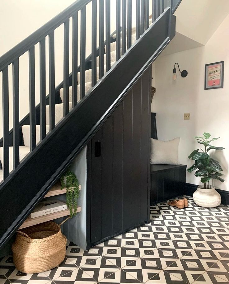 a black and white tiled floor under a stair case