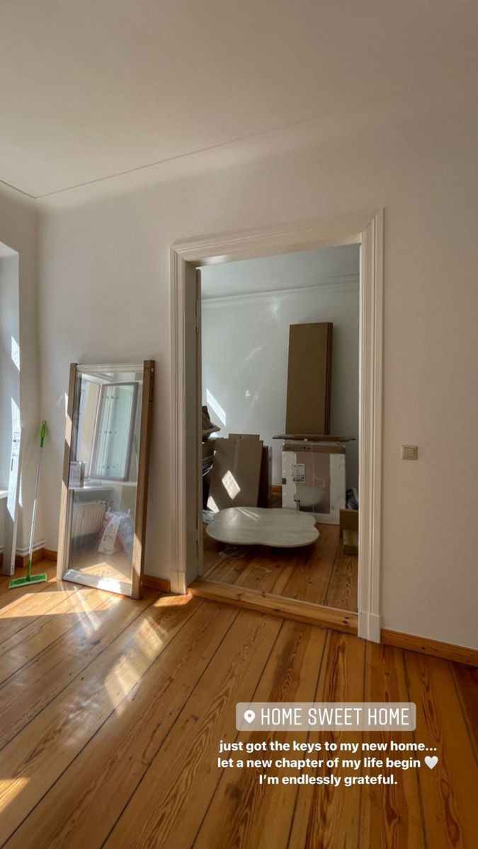 an empty room with wooden floors and white walls