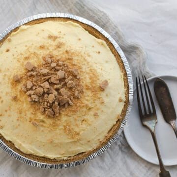 a pie sitting on top of a table next to a fork and silver plate with utensils