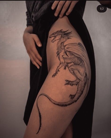 a woman with a dragon tattoo on her thigh