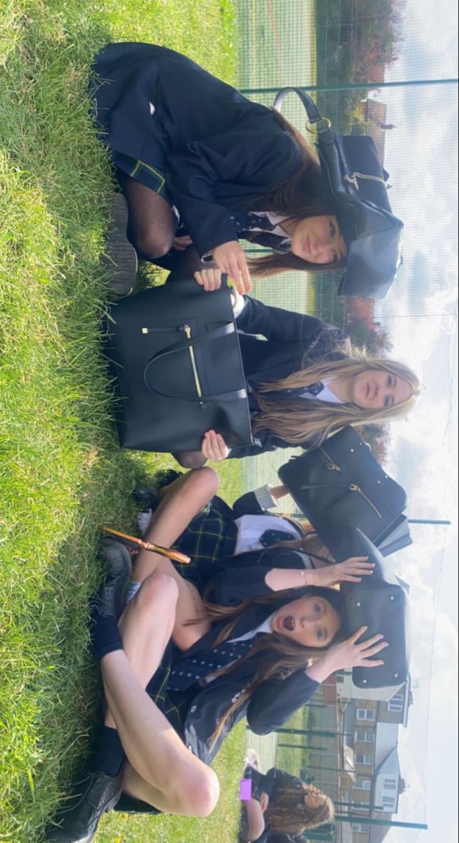 three women standing next to each other in the grass