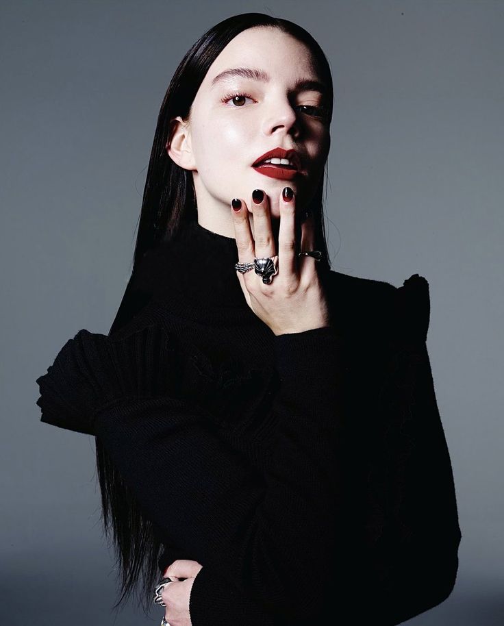 a woman with long black hair and ring on her finger, posing for a photo