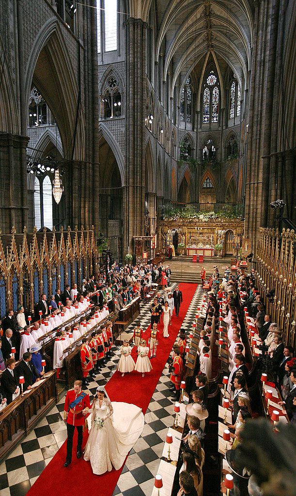 the royal wedding ceremony is being attended by people in red and white outfits, sitting at long tables