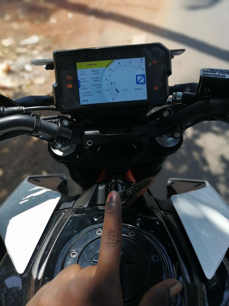 a person on a motor bike with a gps device in their hand and an arrow pointing to the left