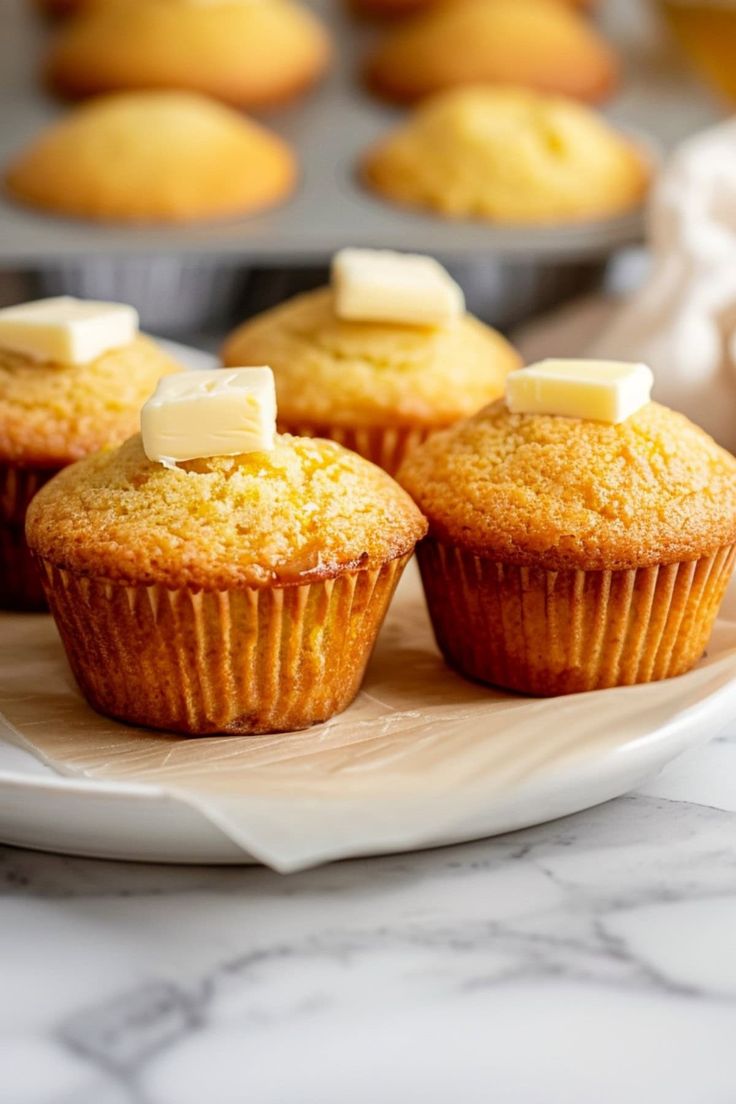 several muffins with butter on top sitting on a plate