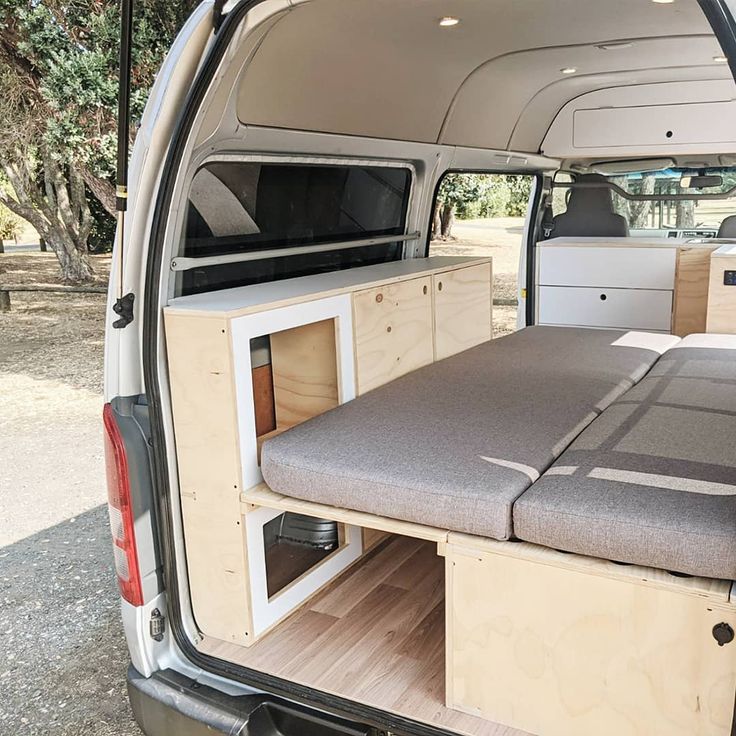 the back end of a van with an open bed and storage compartment on it's side