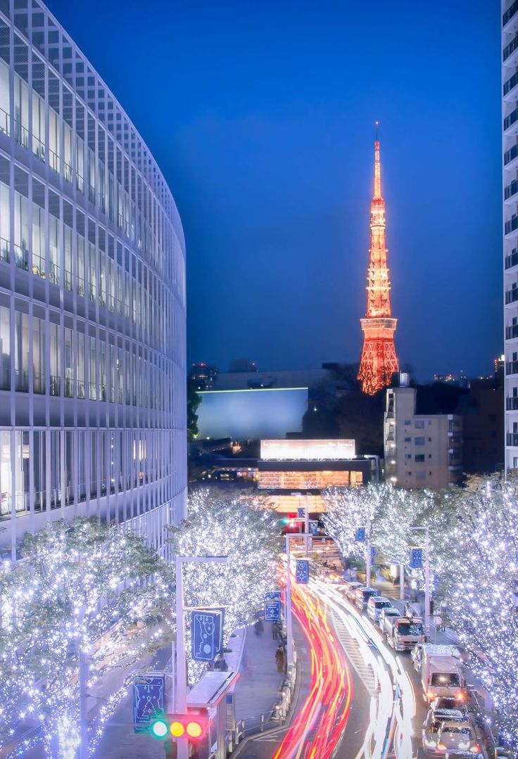 the eiffel tower is lit up with christmas lights in the city at night