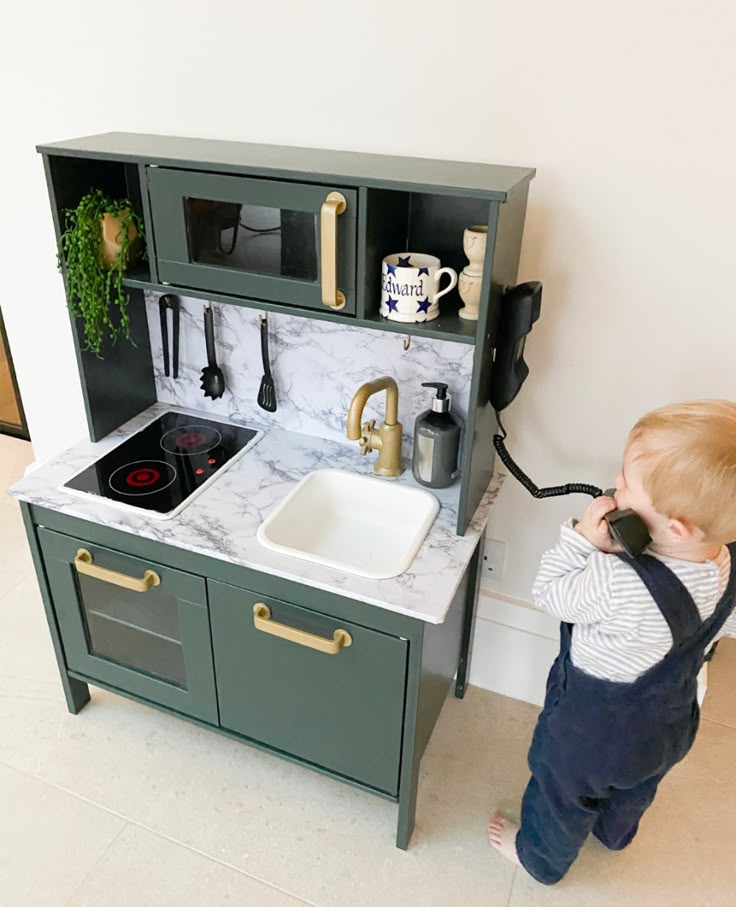 a toddler playing with a toy kitchen set