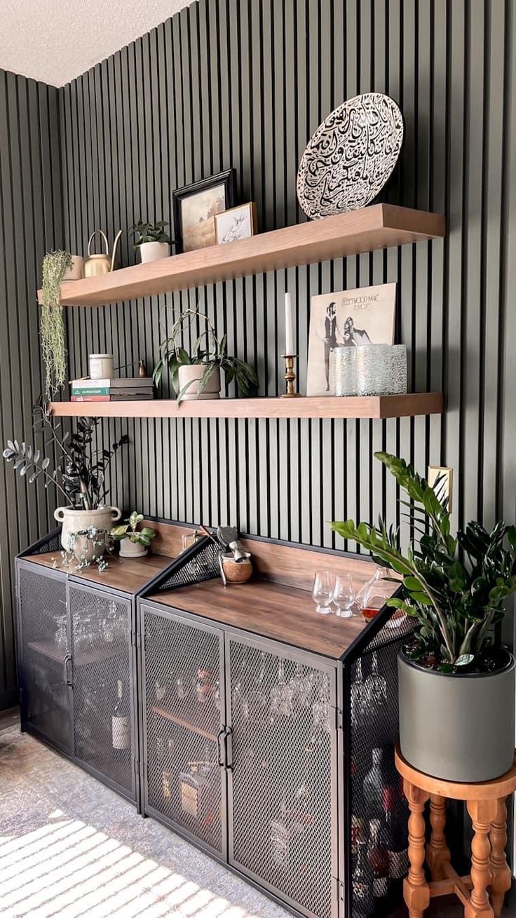 a living room with black and white striped wallpaper, shelves filled with plants and wine glasses