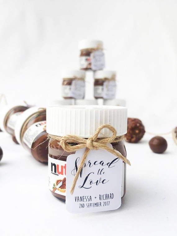 a jar of peanut butter sitting on top of a table next to other jars and nuts