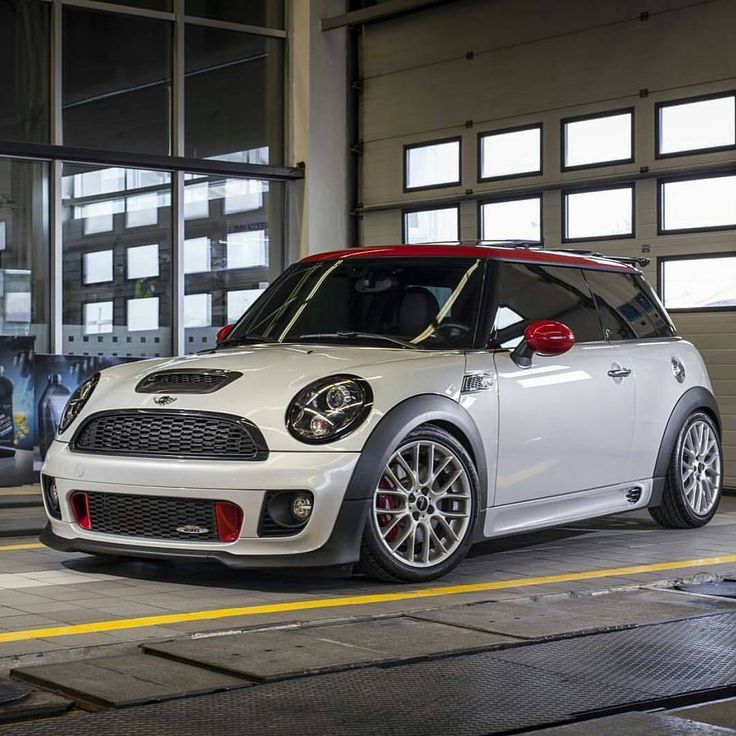 a small white car parked in front of a garage