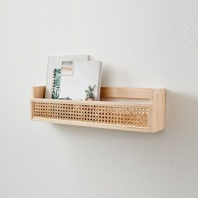 a wooden shelf with pictures on it and a magazine rack attached to the wall behind it