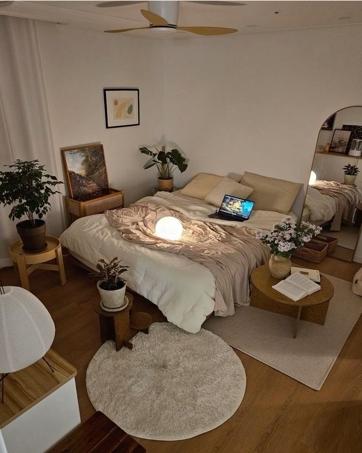 a bed room with a neatly made bed and a laptop on top of the bed