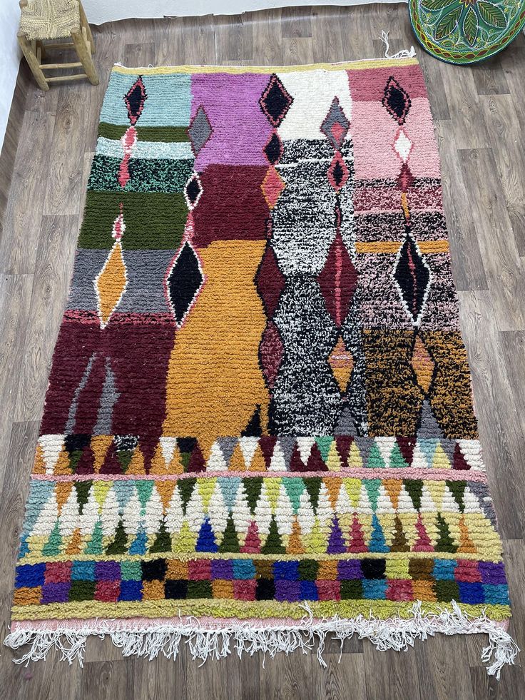 a multicolored rug with fringes on the floor