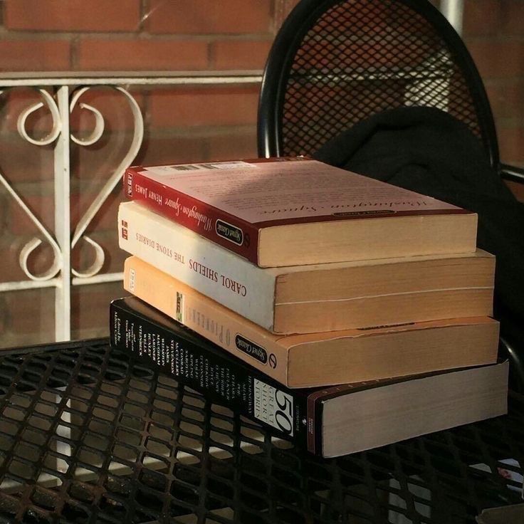 a stack of books sitting on top of a metal table