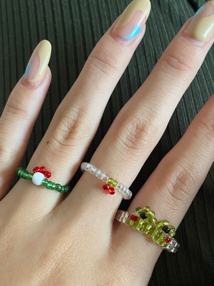 a woman's hand with three rings on it, including an elephant and santa hat