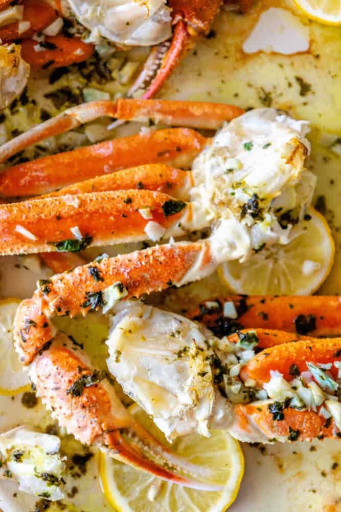 crab legs with lemon wedges and garlic on a platter