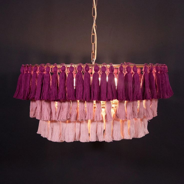 a pink chandelier with tassels hanging from it's sides and lights on the other side