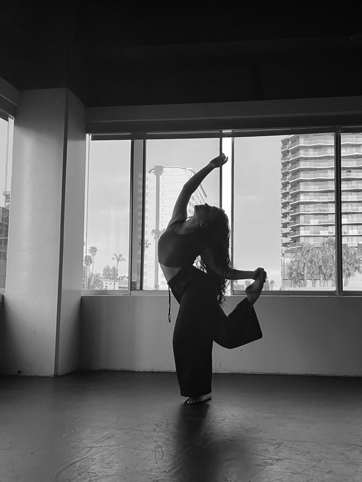 a woman is dancing in an empty room