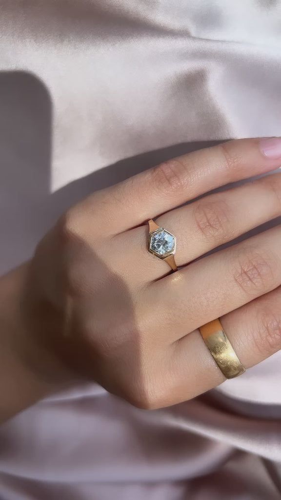 a woman's hand with two gold rings and a diamond ring on her finger