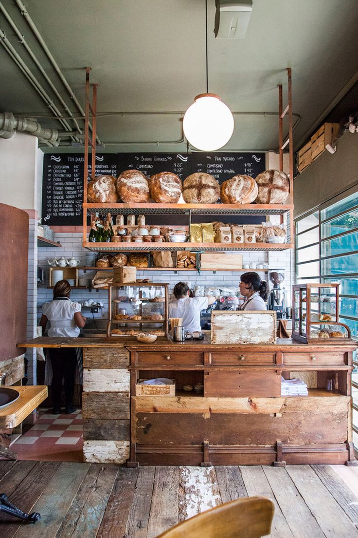 the interior of a bakery with people preparing food