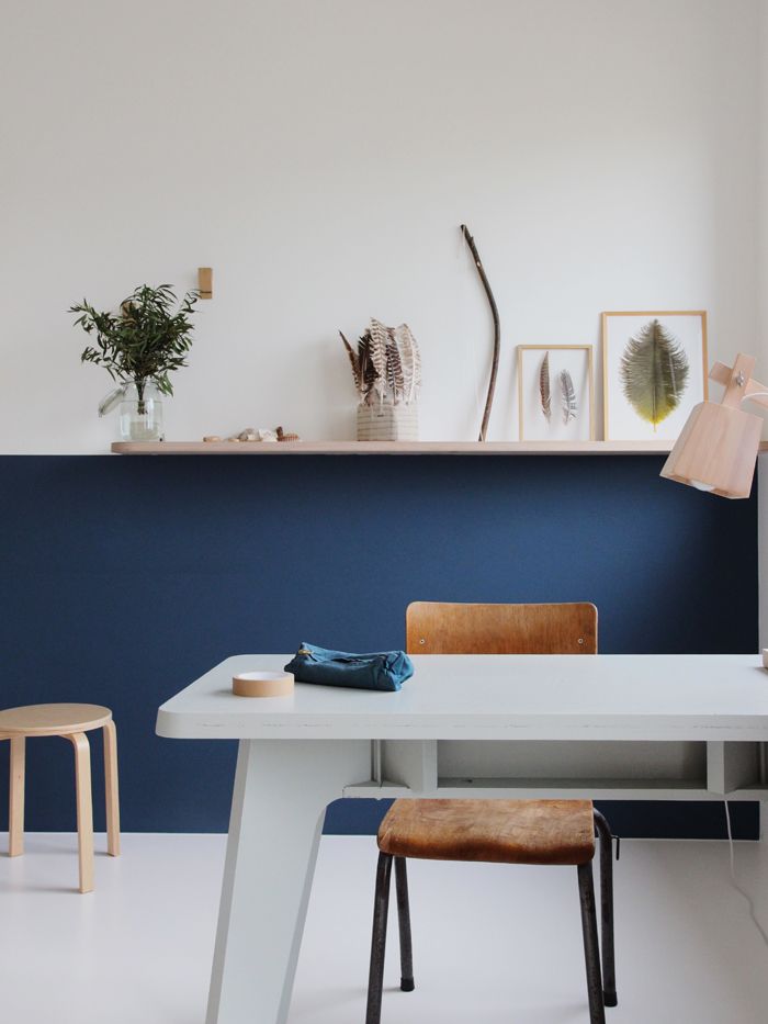 a white table with two chairs next to it and a shelf on the wall behind it