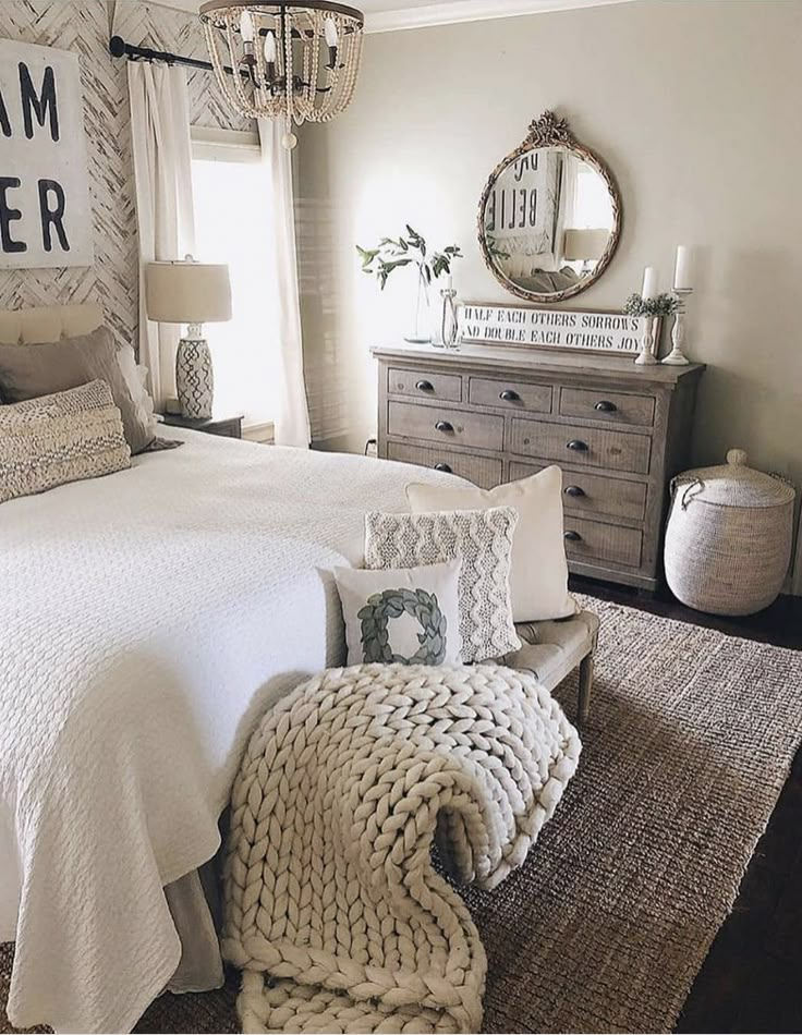 a bedroom with a bed, dresser and mirror on the wall next to a window