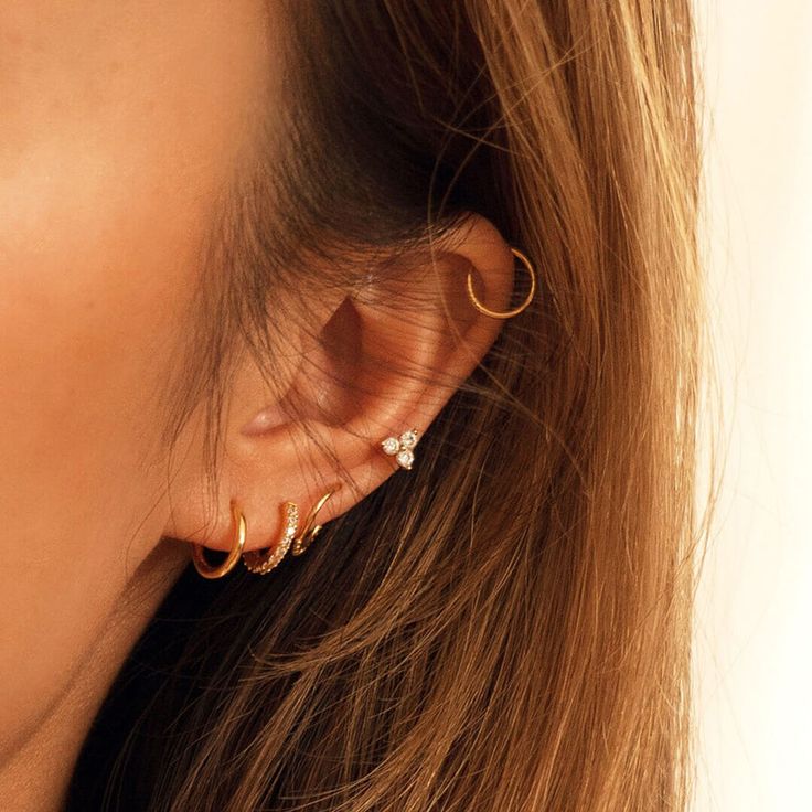 a close up of a woman's ear with two gold rings attached to it