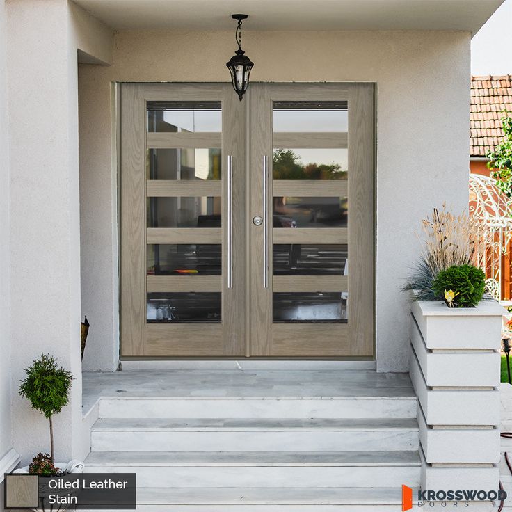 the front door to a house with two glass doors and steps leading up to it